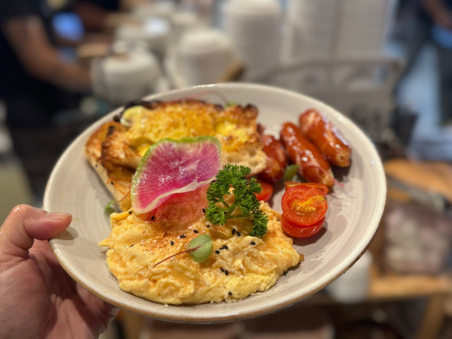 Scrambled eggs with cheesy toast, sausages and tomatoes